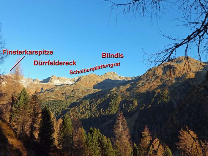 die einsamen Berge nördlich des Trojer Almbachtals; unterhalb des Blindis - im Schatten knapp oberhalb der Waldgrenze - die Knappengruben