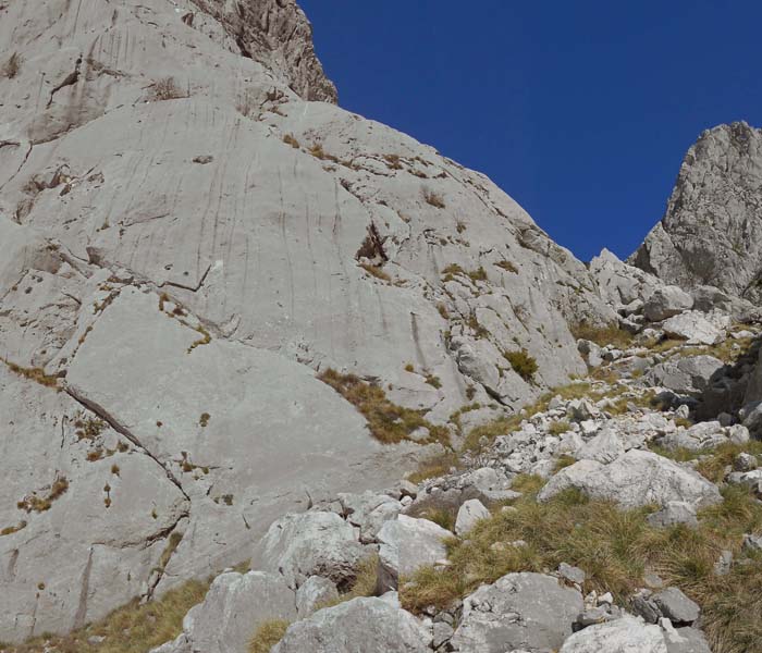 vorbei an den Einstiegen zu zwei weiteren eingerichteten Kletterrouten (hier zu Macchu Picchu, 6b, 5 Seillängen); auch im Kletterführer wird der Zustieg von oben empfohlen, zum Sattel ist es nicht mehr weit