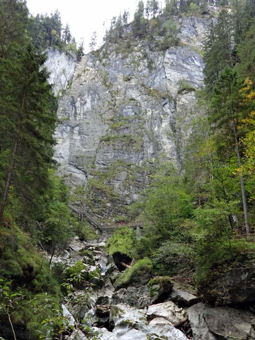 oberhalb der Tropfsteinhöhle zieht der Klettersteig diagonal von rechts unten nach links oben durch die Hauptwand, während die Schluchtsteiganlage abermals den Bach quert ...