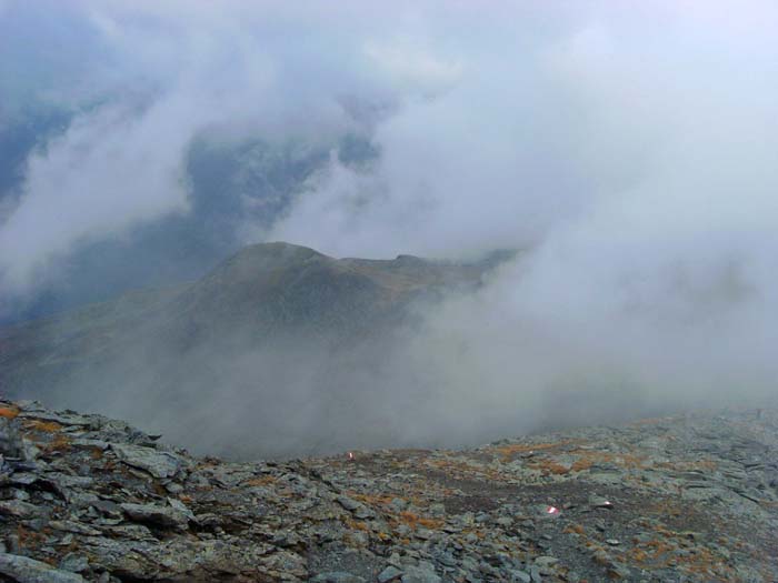 Abstieg am oberen Nordkamm; die Wolken geben für einen kurzen Moment den dritten Gipfel unserer Runde frei - den knapp 300 m niedrigeren Dachskofel