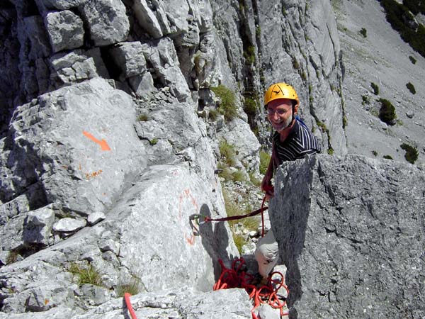 ein roter Pfeil und große Bergrettungshaken markieren den Beginn der Abseilpiste über die Südwand