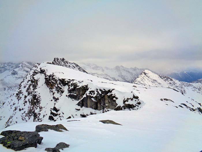 am Gipfel erwartet uns Sturm und leichter Schneefall; Blick gegen SO auf den 26 m höheren Hauptgipfel und die Aderspitze