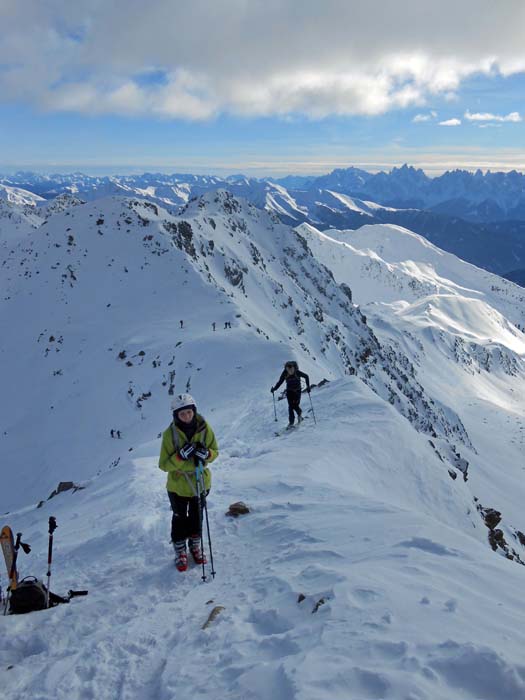 die letzten Meter am Gipfelgrat; rechts hinten die Zackenkronen der Sextener Dolomiten (Dreischusterspitze und Haunold)